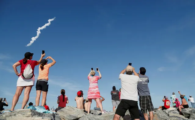 Spectators at Cocoa Beach watch SpaceX's first Falcon Heavy rocket launch from the Kennedy Space Center, Florida, February 6, 2018. (Photo by Gregg Newton/Reuters)