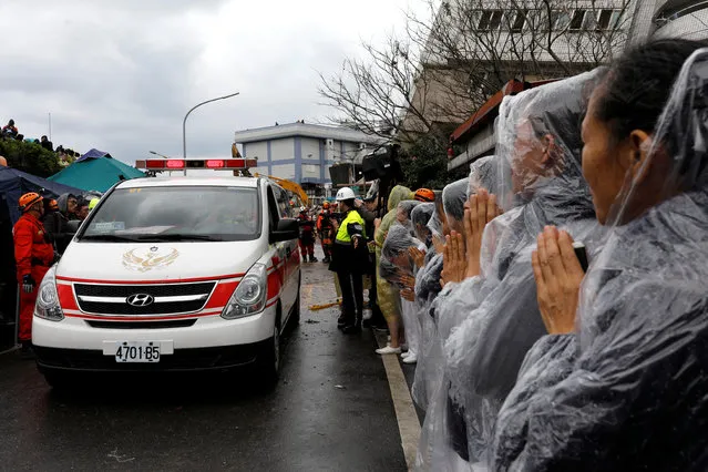 Volunteers pray as a dead body is transferred by ambulance from a collapsed building in Hualien, Taiwan February 8, 2018. (Photo by Tyrone Siu/Reuters)