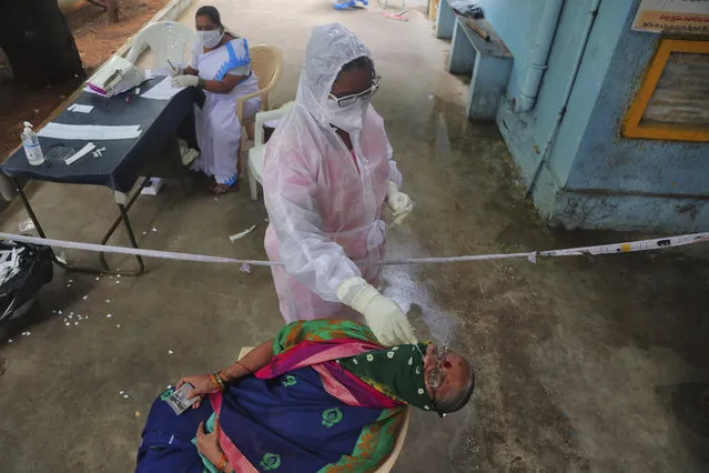 A health worker collects a nasal swab sample to test for COVID-19 in Hyderabad, India, Monday, September 21, 2020. (Photo by Mahesh Kumar A./AP Photo)