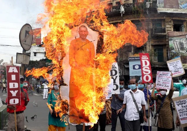 Activists of Socialist Unity Centre of India (SUCI) shout slogans and burn a cut-out of Yogi Adityanath, Chief Minister of the northern state of Uttar Pradesh, during a protest after the death of a rape victim, who was brought from a hospital in Uttar Pradesh to New Delhi's Safdarjung Hospital, where she died while undergoing treatment on Tuesday, in Kolkata, India, September 30, 2020. (Photo by Rupak De Chowdhuri/Reuters)