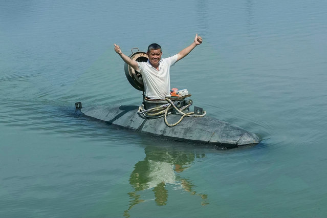 This photo taken on July 2, 2025 shows Chinese farmer Zhang Shengwu posing in his homemade submarine in a river in Hanshan county, in China's eastern Anhui province. A 60-year-old farmer in China has built his own “Big Black Fish” – a homemade submarine that can accommodate two people, dive eight metres and stay underwater for 30 minutes at a time. Zhang recently launched his five-ton sub into the river near his rural home, state broadcaster CCTV reported on July 17. (Photo by AFP Photo/China Stringer Network)
