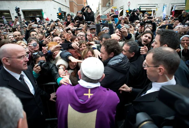 Pope Francis I greets the crowds after conducting a mass in Saint Anna church inside the Vatican, in a picture released by Osservatore Romano at the March 17, 2013. Pope Francis took on the role of a simple parish priest on Sunday, saying Mass for the Vatican's resident community and urging listeners to not to be so quick to condemn others for their failings. (Photo by Osservatore Romano/Reuters)