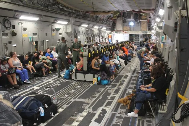 Families settle into their seats aboard a Boeing C-17A Globemaster III aircraft for evacuation from Naval Station Guantanamo Bay ahead of Hurricane Matthew, in Guantanamo Bay, Cuba October 2, 2016 in a photo provided by the U.S. Navy. The United States was airlifting some 700 spouses and children to Florida from its Guantanamo Bay naval base. Prisoners and service personnel would remain. (Photo by Capt. Frederick H. Agee/Reuters/U.S. Navy)