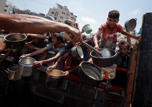 Palestinians gather to receive food from a charity kitchen, amid a hunger crisis, in Gaza City on July 28, 2025. (Photo by Khamis Al-Rifi/Reuters)