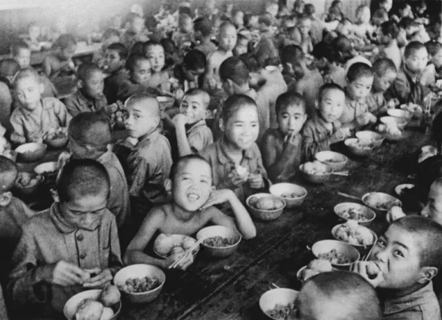 War orphans eat together at an orphanage in Tokyo  in 1946. In Japan, war orphans were punished for surviving. They were bullied. They were called trash, sometimes rounded up by police and put in cages. Some were sent to institutions or sold for labor. They were targets of abuse and discrimination. A 1948 government survey found there were more than 123,500 war orphans nationwide. But orphanages were built for only for 12,000, leaving many homeless. (Photo by Kyodo News via AP Photo)