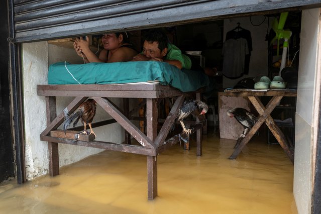 People lie on an elevated bed amid flooding caused by monsoon rains in Cainta, Rizal, Philippines, on July 22, 2025. (Photo by Eloisa Lopez/Reuters)