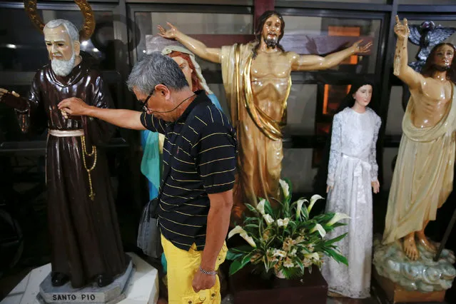 A man touches a religious statue after a service in a chapel at Camp Crame, the headquarters of Philippine National Police (PNP) in Manila, Philippines October 9, 2016. (Photo by Damir Sagolj/Reuters)