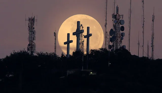The full moon is seen behind the hill of the three crosses in Cali, Colombia,September 17, 2016. (Photo by Jaime Saldarriaga/Reuters)