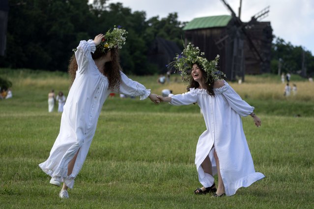 Ukrainian young women dressed in traditional clothing dance at a traditional Midsummer Night celebration near capital Kyiv, Ukraine, Sunday, June 23, 2024. The age-old pagan festival is still celebrated in Ukraine amid the third year of Russia-Ukraine war. (Photo by Efrem Lukatsky/AP Photo)