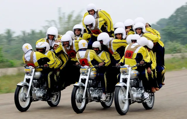 Members of the Motor display team from Army Service Corps (ASC) known as the 'Tornadoes' attempt the World record of the fastest moving human pyramid, in Bangalore, India,  15 November 2015. The Tornadoes successfully attempted the record with 32 men on three 500cc motorcycles covering a distance of 1Km. (Photo by Jagadeesh N.V./EPA)
