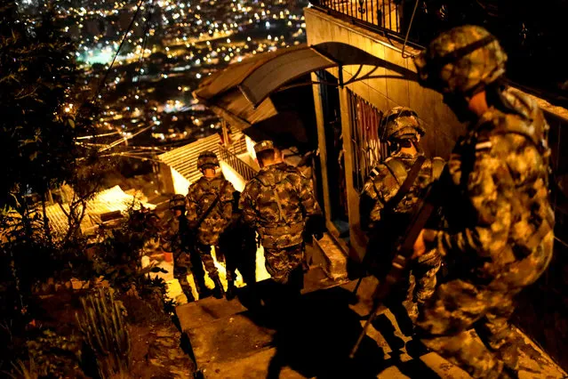 Soldiers patrol the alleys of the Comuna 13 neighbourhood in Medellin, Antioquia Department, Colombia, on April 27, 2018. The Comuna 13 neighbourhood was militarized after gang violence increased following the arrest on April 21 of several gang leaders, including that of Cristian Camilo Mazo Castaneda, aka Sombra, leader of the Robledo gang. (Photo by Joaquin Sarmiento/AFP Photo)