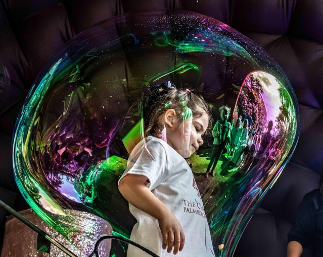 A young lady is engulfed by a giant bubble during a bubble show at The Chabad House Palm Beach Chanukah Wonderland event in the courtyard of the Colony Hotel in Palm Beach, Florida on December 23, 2024. (Photo by USA Today)