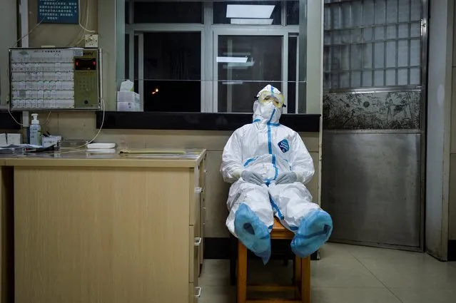 A medical worker in a protective suit takes a break during her night shift at a community health service center, which has an isolated section to receive patients with mild symptoms caused by the coronavirus and suspected patients, in Qingshan district of Wuhan, Hubei province, February 9, 2020. (Photo by Reuters/China Daily)