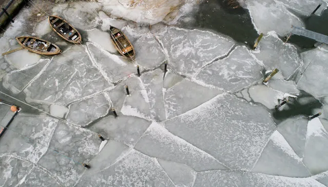 This aerial picture taken with a drone on March 21, 2018 shows fisher boats caught in the ice at the harbour of Stahlbrode, northeastern Germany, where the low temperatures brought fishing activities to a standstill. (Photo by Stefan Sauer/AFP Photo/DPA)