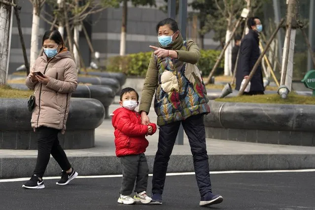 Residents wearing masks to help curb the spread of the coronavirus in Wuhan, China, on Tuesday, January 26, 2021. The central Chinese city of Wuhan where the coronavirus was first detected has largely returned to normal but is on heightened alert against a resurgence as China battles outbreaks elsewhere in the country. (Photo by Ng Han Guan/AP Photo)