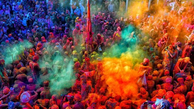 Hindu devotees play with colorful powders (Gulal) at the Radharani Temple of Nandgaon, India during the festival on March 12, 2022. Holi Festival of India is one of the biggest colorful celebrations in India as many Tourists and devotees gather to observe this colorful event. Marking the beginning of spring, the festival celebrates the divine love of Radha and Krishna and represents the victory of good over evil. (Photo by Avishek Das/SOPA Images/LightRocket via Getty Images)