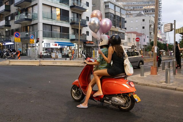 People ride a scooter in Tel Aviv, on August 7, 2024, amid regional tensions during the ongoing war between Israel and the Palestinian Hamas movement in the Gaza Strip. (Photo by Oren Ziv/AFP Photo)