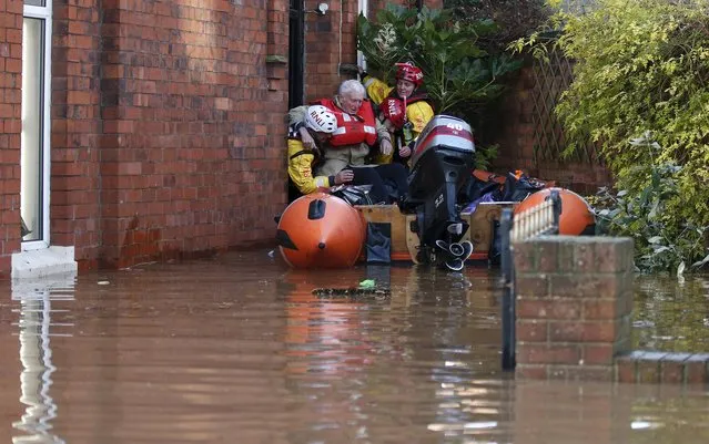 Rescue workers remove an elderly man from a flooded house on a residential street in Carlisle, Britain December 6, 2015. (Photo by Phil Noble/Reuters)