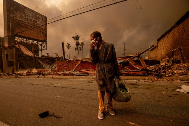 A man walks past a fire-ravaged business after the Eaton Fire swept through Wednesday, January 8, 2025, in Altadena, Calif. (Photo by Ethan Swope/AP Photo)