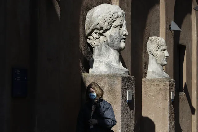 A museum usher stands by marble busts at the entrance of the Sant'Angelo castle In Rome Tuesday, March 2, 2021. The first anti-pandemic decree from Italy’s new premier, Mario Draghi, tightens measures governing school attendance while easing restrictions on museums, theaters and cinemas. Italy, a nation of 60 million people where COVID-19 first erupted in the West in February 2020, has registered nearly 3 million confirmed cases. Its known death toll of more than 98,000,is the second-highest in Europe, after Britain’s. (Photo by Gregorio Borgia/AP Photo)