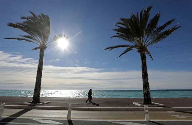 People, wearing protective face masks, walk on the Promenade des Anglais in Nice amid the coronavirus disease (COVID-19) outbreak in France, January 25, 2021. (Photo by Eric Gaillard/Reuters)