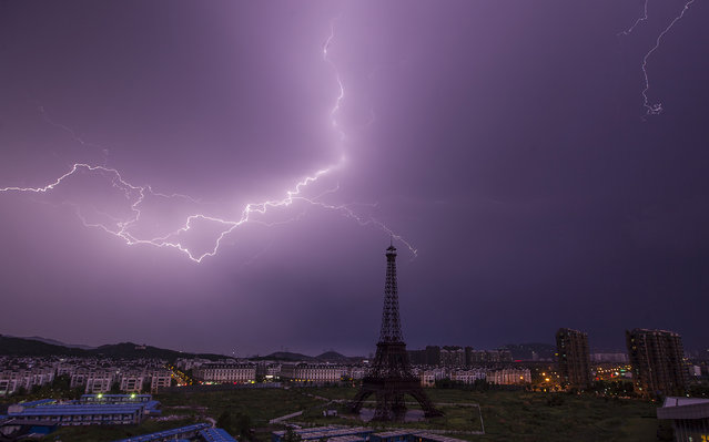 A lightning bolt streaks across the sky above a replica of the Eiffel Tower at the Tianducheng development in Hangzhou, Zhejiang Province August 1, 2013. (Photo by Aly Song/Reuters)