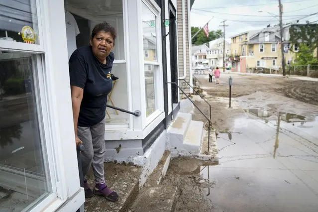 Kathy Eason, a worker at the Center for Highland Falls, stands on the storefront's stoop where she had been trapped by floodwaters the previous day, Monday, July 10, 2023, in Highland Falls, N.Y. Scientists have long warned that more extreme rainfall is expected in a warming world. (Photo by John Minchillo/AP Photo)