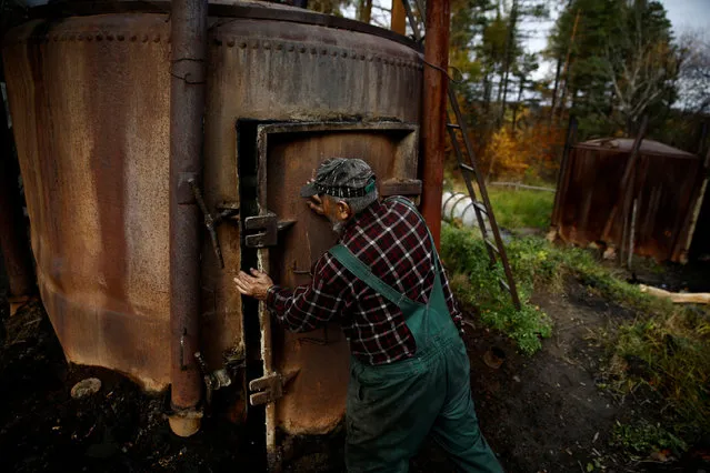 Charcoal burner Zygmunt Furdygiel closes a charcoal furnace full of wood at a charcoal making site in the forest of Bieszczady Mountains, near the village of Baligrod, Poland October 27, 2016. (Photo by Kacper Pempel/Reuters)