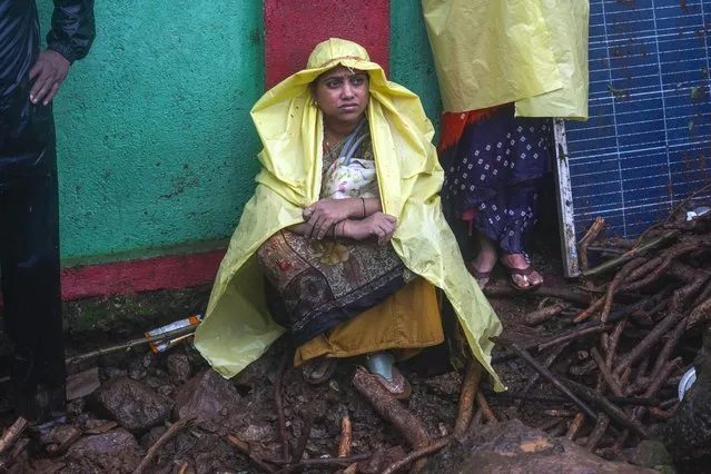 Family members of people trapped under rubble wait for news of rescue after a landslide washed away houses in Raigad district, western Maharashtra state, India, Thursday, July 20, 2023. While some people are reported dead many others feared trapped under piles of debris. (Photo by Rafiq Maqbool/AP Photo)