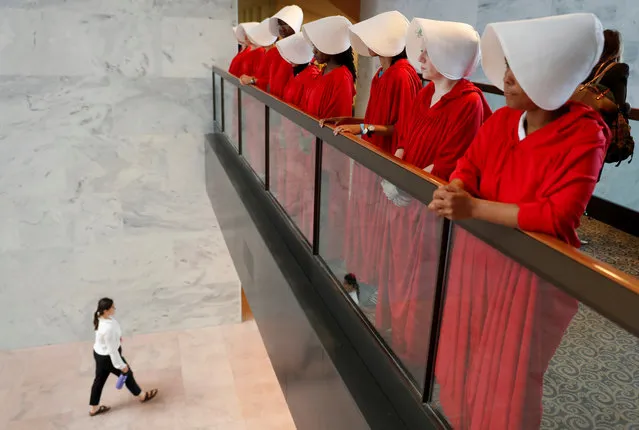 Demonstrators dressed as handmaidens await the arrival of U.S. Supreme Court nominee judge Brett Kavanaugh prior to his appearance before a Senate Judiciary Committee confirmation hearing on Capitol Hill in Washington on September 4, 2018. (Photo by Joshua Roberts/Reuters)