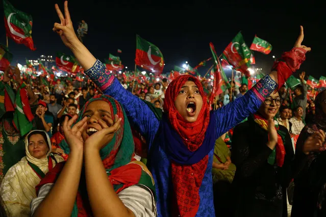 Supporters of Imran Khan, head of Pakistan Tehrik-e-Insaf (PTI) political party listen to his speech, during an election campaign in Karachi, Pakistan, 22 July 2018. Pakistan is set to hold general and provincial elections on 25 July with around 105 million people registered to vote, according to the election commission. (Photo by Shahzaib Akber/AFP Photo)