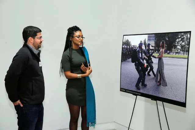 Ieshia Evans (R) speaks to Reuters freelance photographer Jonathan Bachman beside his photo that she is featured in at the “Iconic in an Instant? One Trillion Images” panel event hosted by Reuters and ICP at ICP in Manhattan, New York, U.S., December 5, 2016. (Photo by Andrew Kelly/Reuters)