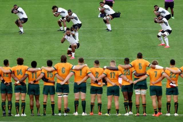 Players of Australia look on as Waisea Nayacalevu of Fiji leads his teammates as players of Fiji perform the Cibi prior to the Rugby World Cup France 2023 match between Australia and Fiji at Stade Geoffroy-Guichard on September 17, 2023 in Saint-Etienne, France. (Photo by Catherine Ivill/Getty Images)