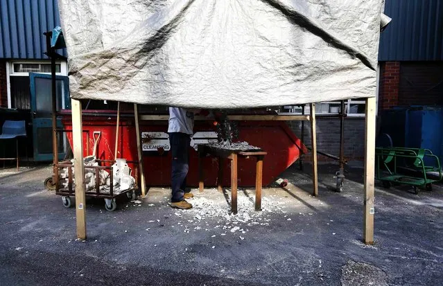 Worker Stephen Richardson cuts off the form during the production of the mascots. (Photo by Stefan Wermuth/Reuters)