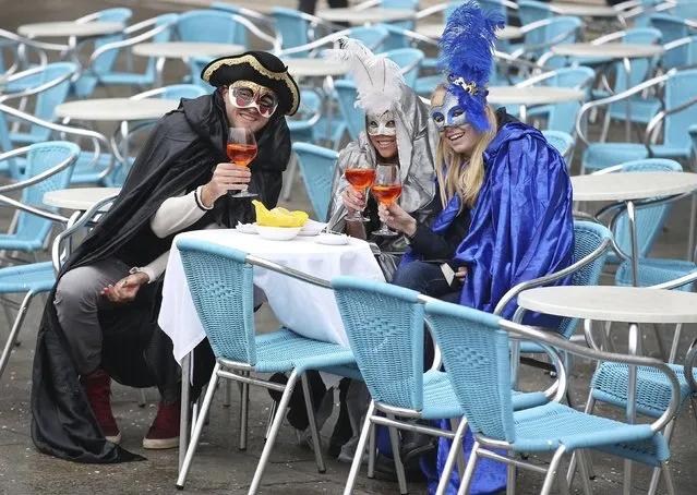 Masked revellers pose with their drinks in San Marco Piazza during the Venice Carnival, January 30, 2016. (Photo by Alessandro Bianchi/Reuters)