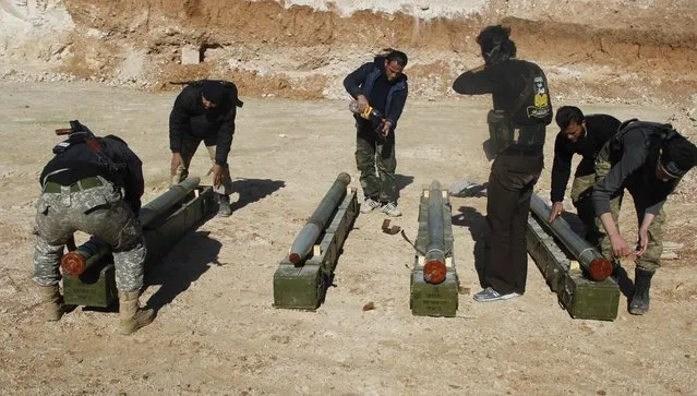 Rebel fighters prepare Grad rockets to be launched toward forces of Syria's President Bashar al-Assad stationed in al-Suqaylabiyah district, from the orchards north of Kfar Zeita village in the northern countryside of Hama January 29, 2015. (Photo by Mohamad Bayoush/Reuters)