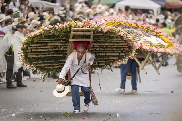 Silleteros, farmers, carry flower arrangements during parade in Flower Fair on August 15, 2022 in Medellin, Colombia. Traditional Silleteros Parade is held to commemorate the beginning of farmers' selling silletas known as flower arrangements at the markets. (Photo by Luis Bernardo Cano/Anadolu Agency via Getty Images)