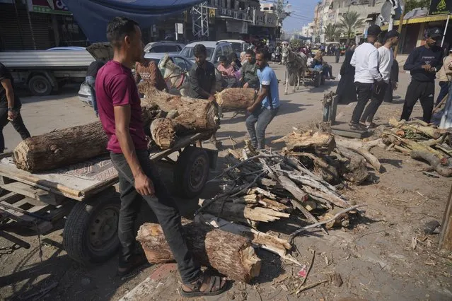 Palestinians sell firewood during the ongoing bombardment of the Gaza Strip in Deir al Ballah, Saturday, November 18, 2023. (Photo by Hatem Moussa/AP Photo)