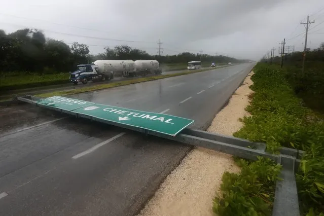 A road sign brought down by the winds of Hurricane Grace straddles one lane of a highway in Tulum, Quintana Roo state, Mexico, Thursday, August 19, 2021. (Photo by Marco Ugarte/AP Photo)