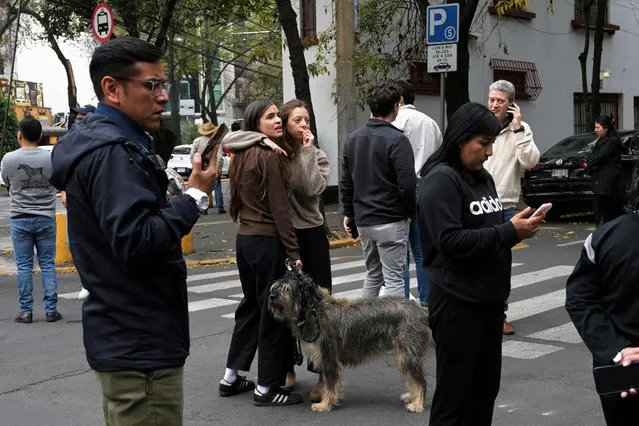 People wait in the street after an earthquake in Mexico City on December 7, 2023. A 5.8-magnitude earthquake shook much of central Mexico Thursday including the capital, prompting people to run out into the streets, the country's seismological institute said. (Photo by Rodrigo Arangua/AFP Photo)
