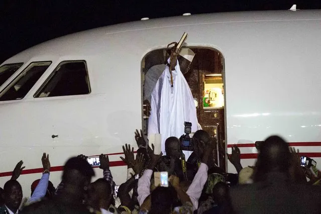 Gambia's defeated leader Yahya Jammeh waves to supporters as he departs from Banjul airport Saturday January 21, 2017. Jammeh announced early Saturday he has decided to relinquish power, after hours of last-ditch talks with regional leaders and the threat by a regional military force to make him leave. (Photo by Jerome Delay/AP Photo)