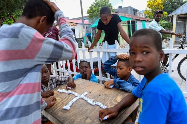 People who displaced from their homes by a recent earthquake play dominoes at a tent encampment  on August 20, 2021 in L'Saile, Haiti. The magnitude 7.2 earthquake last week in the southwest area of Haiti has killed over 2,000 people leaving thousands homeless and searching for food.(Photo by Joshua Lott/The Washington Post)