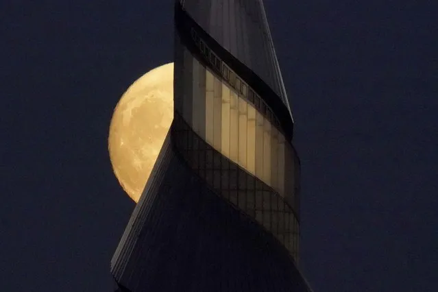 The waxing moon rises beyond the 300-foot-tall stainless steel spire at the Community of Christ temple Sunday, September 19, 2021, in Independence, Mo. (Photo by Charlie Riedel/AP Photo)