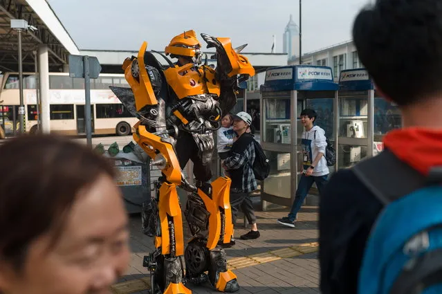 A street artist performs in a costume as Bumblebee, a character from the Transformers film franchise, near the Victoria Harbour waterfront in Tsim Sha Tsui, Hong Kong, China, 03 March 2019. During weekends the Tsim Sha Tsui waterfront attracts street performers and tourists alike. (Photo by Jerome Favre/EPA/EFE)
