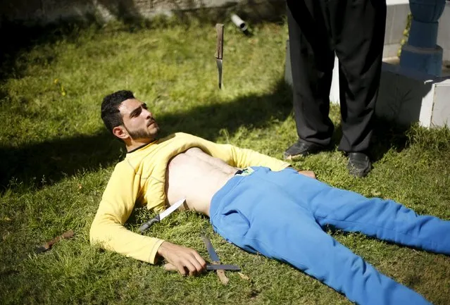 Palestinian Mohammad Baraka, 20, nicknamed by people as Gaza Samson, has knives dropped on his stomach as he exercises in Deir al-Balah in the central Gaza Strip March 5, 2016. Mohammad Baraka who prefers to be known as “The Incredible”, perhaps because he lacks the original Samson's long hair, has been putting on displays in his hometown of Deir al-Balah for the past two years, earning a reputation as the strongest man in the Gaza Strip. (Photo by Mohammed Salem/Reuters)