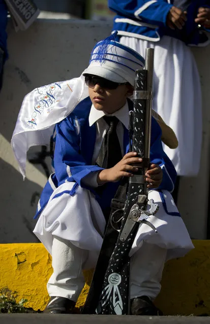 A boy dressed as a French soldier awaits the start of Cinco de Mayo celebrations in the Penon de los Banos neighborhood of Mexico City, Tuesday, May 5, 2015. (Photo by Rebecca Blackwell/AP Photo)