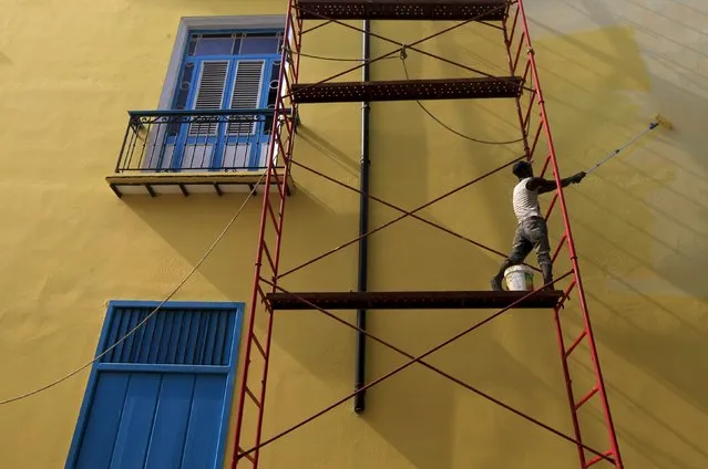 A man paints a building in Old Havana March 17, 2016. (Photo by Enrique De La Osa/Reuters)