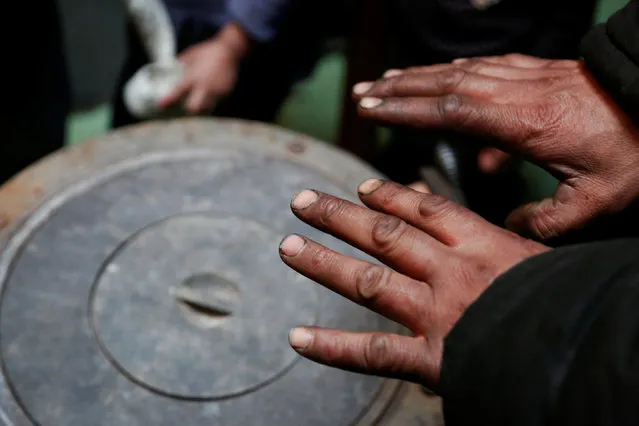 Setevdorj Myagmartsogt holds his hands above his new coal burning stove while talking to reporters in Ulaanbaatar, Mongolia January 29, 2017. Setevdorj Myagmartsogt lives with his wife, four children and two relatives in his cramped ger home above a coal depot not far from the city centre. The government offers free electricity to homes without access to city's central heating grid, but electric heating units are too expensive to families like Myagmartsogt's. The family doesn't have access to their own electricity line and borrows it from a neighbour. (Photo by B. Rentsendorj/Reuters)