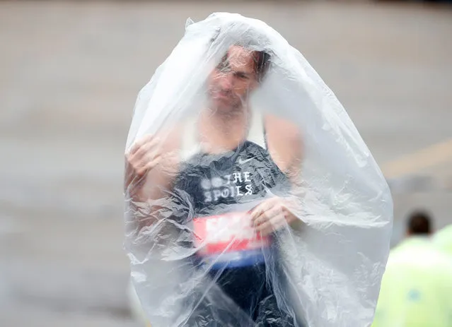 Runner Kyle Rodemacher struggles with his poncho prior to the 2019 Boston Marathon in Boston, US on April 15, 2019. (Photo by Greg M. Cooper/USA Today Sports)