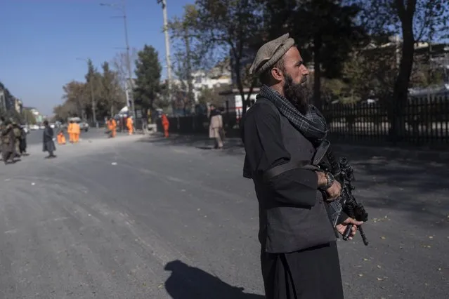 A Taliban fighter secures the area after a roadside bomb went off in Kabul Afghanistan, Monday November 15, 2021. The bomb exploded on a busy avenue in the Afghan capital on Monday, wounding two people, police said. (Photo by Petros Giannakouris/AP Photo)